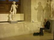 An artist sketches a statue at the Louvre.
