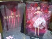 An official Moulin-Rouge-themed Barbie sits in a shop window. Barbie is everywhere and in every profession, including topless dancing.